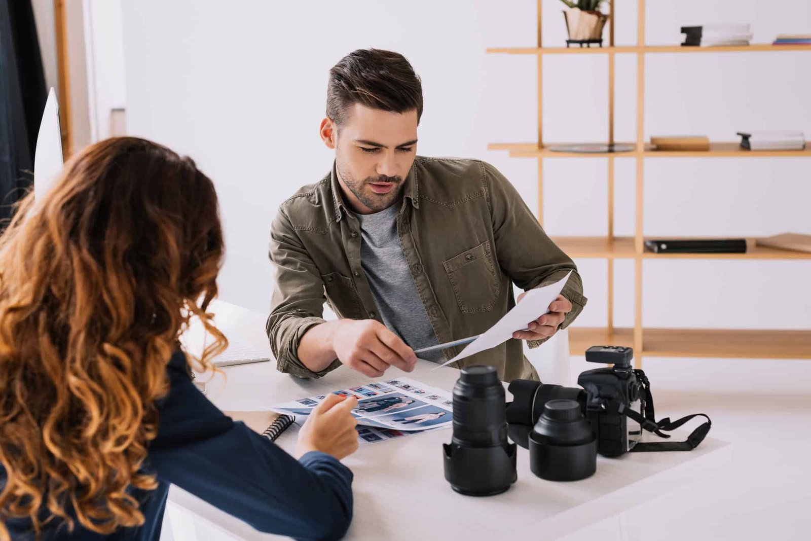 male-photographer-and-model-choosing-photos-for-portfolio-in-modern-office